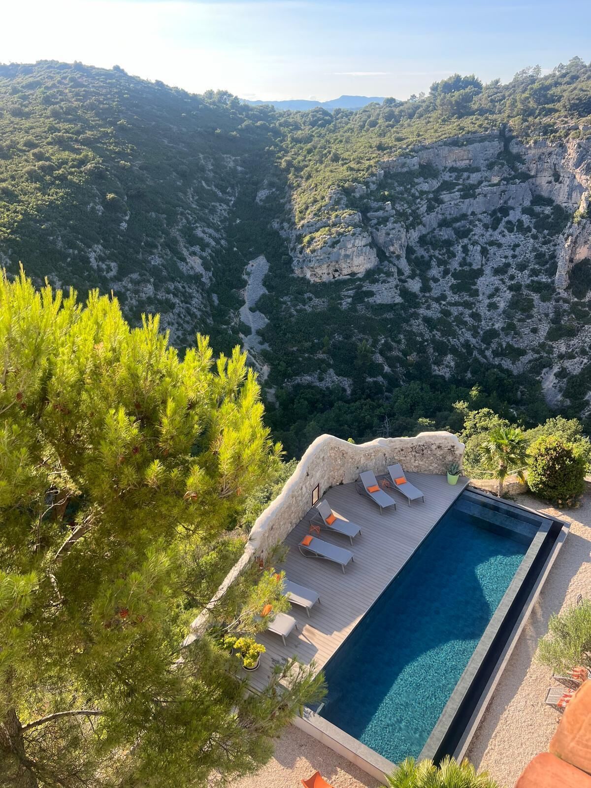 Una piscina con sillas de descanso y vistas a un paisaje montañoso.