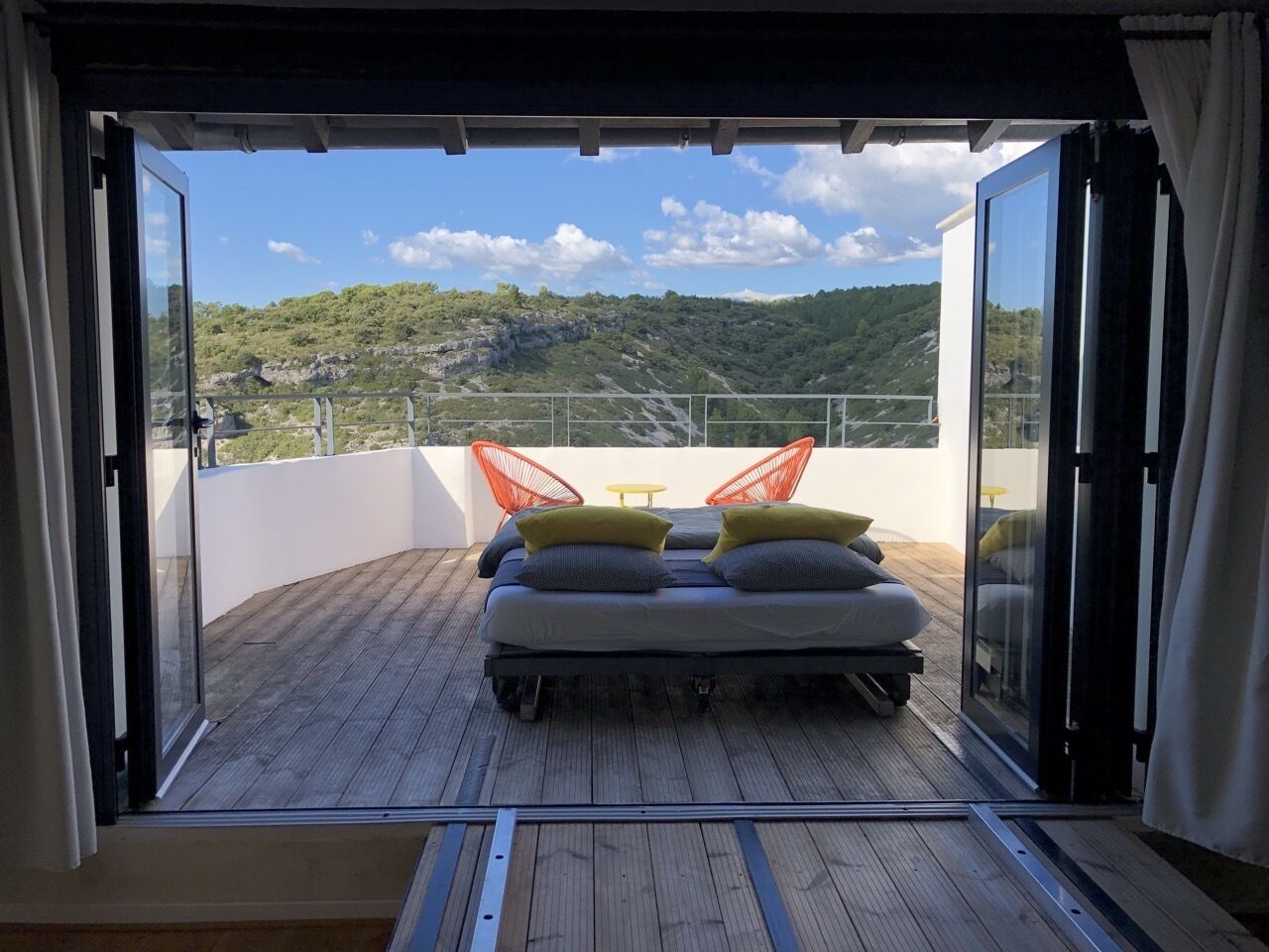 Un balcon avec un lit, une table et des chaises.
