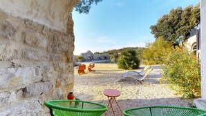 A stone wall, outdoor seating, a pool, and a view of the landscape. - Metafort (Méthamis)
