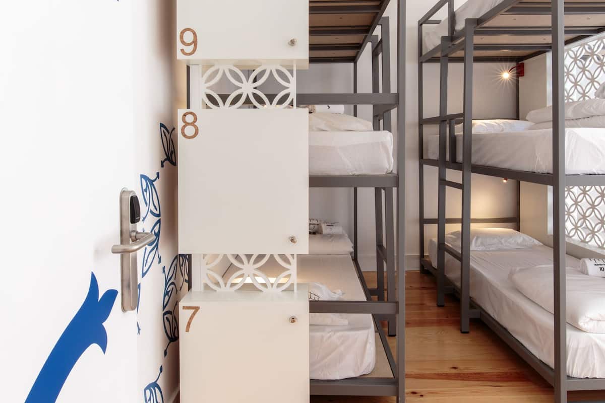 Un dormitorio con literas, una pared blanca con números y suelo de madera.
