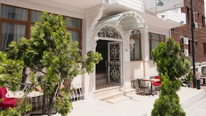 A hotel entrance with a white facade, ornate metalwork, and a sign reading "mevlana hotels". - Mevlana Hotel (Istanbul)