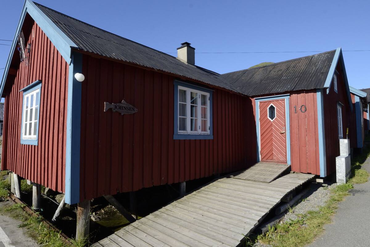 A red wooden building with a sign reading "JOHNSEN" and a number "10" on the door.