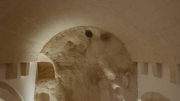 An arched doorway with rough, textured walls and a small circular window.