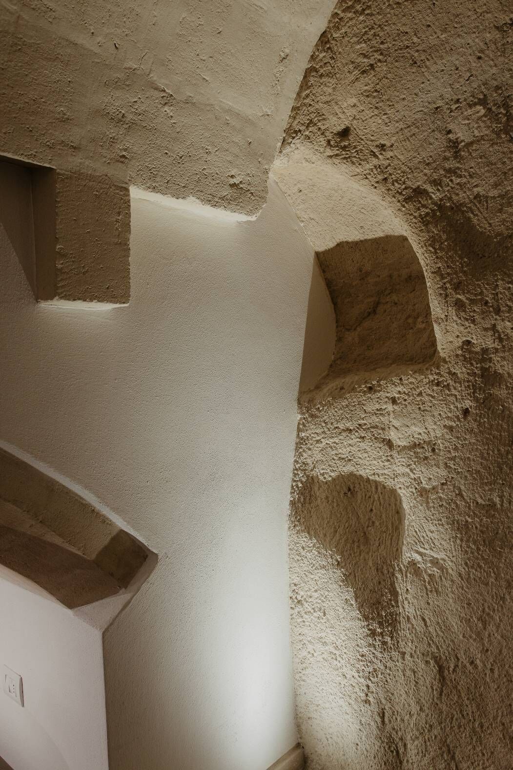 Esquina de una habitación con pared texturizada y techo blanco.
