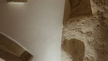 Esquina de una habitación con pared texturizada y techo blanco.