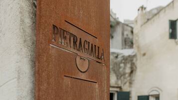 Un letrero con el nombre 'PIETRAGIALLA' sobre un poste de madera, que indica un lugar o establecimiento.