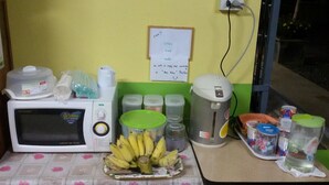 A kitchen area with a microwave, a coffee maker, and various containers. - Bansabai Raiwan Resort (Chanthaburi)