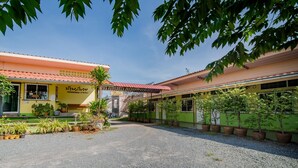 A building with a red roof and a sign in a foreign language. - Bansabai Raiwan Resort (Chanthaburi)