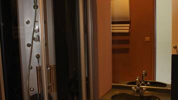 Une salle de bain avec une douche à parois de verre, un lavabo et un miroir.