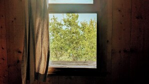 A window with a view of a lake and forested hills. - Cabanes et Lodges du Belvedere (Serrières-sur-Ain)