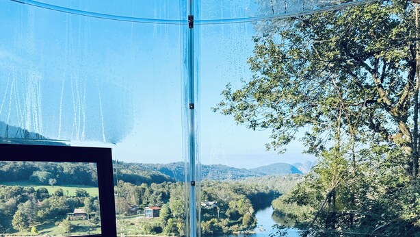 A hot tub with a view of a river and forest. - Cabanes et Lodges du Belvedere (Serrières-sur-Ain)