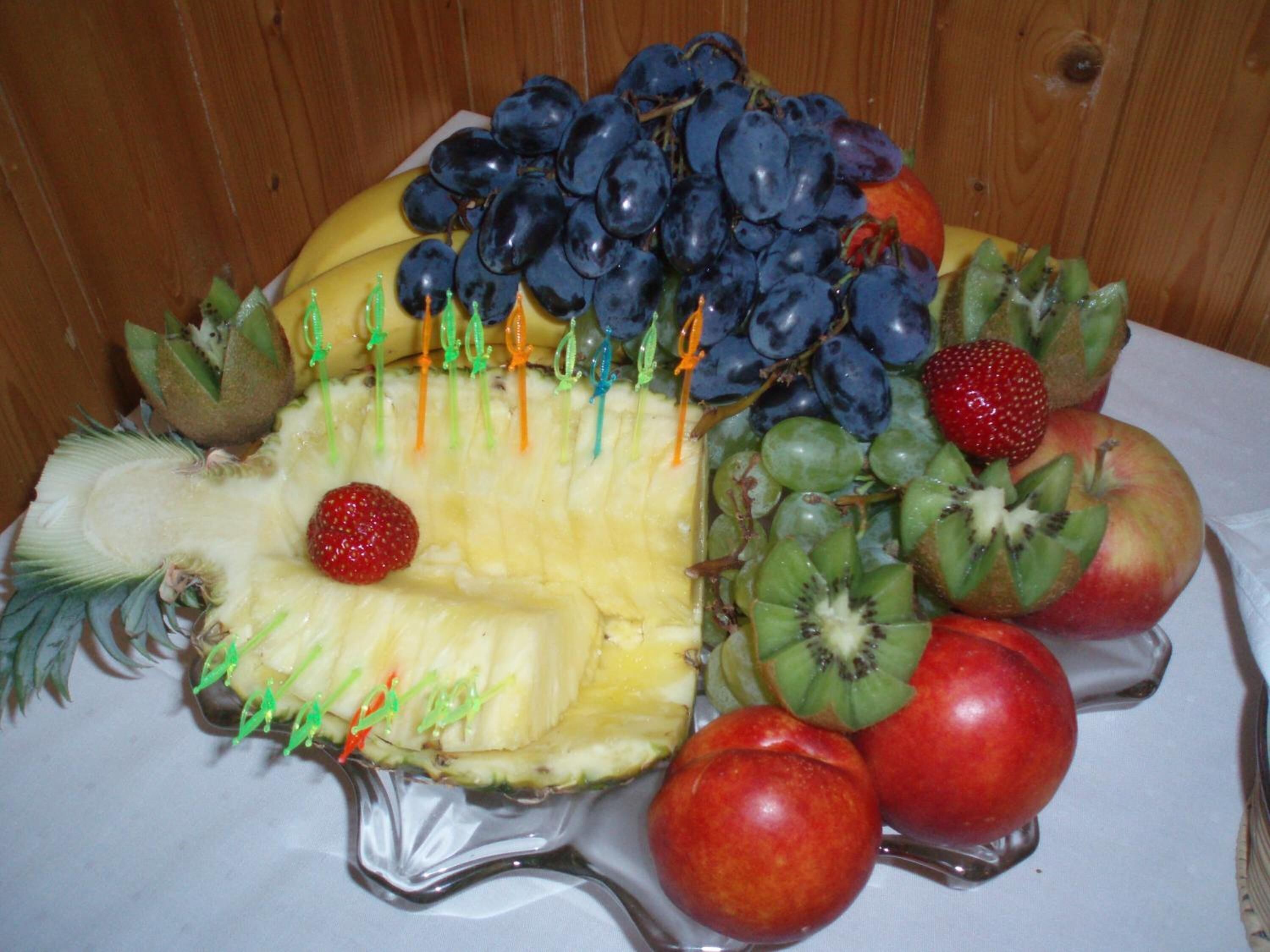 A fruit arrangement on a table with a wooden background.