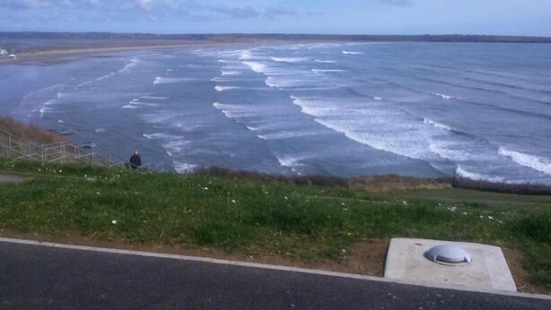 A coastal road with a sidewalk and a grassy area. - The Vee B&B (Waterford)