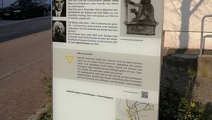 A historical information board with text and photographs, including a statue of a figure in a crown. - Hotel Garni Elisabeth (Goeppingen)