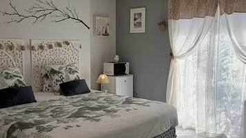 Une chambre à coucher avec un lit, une lampe, un téléviseur et un mur décoratif.