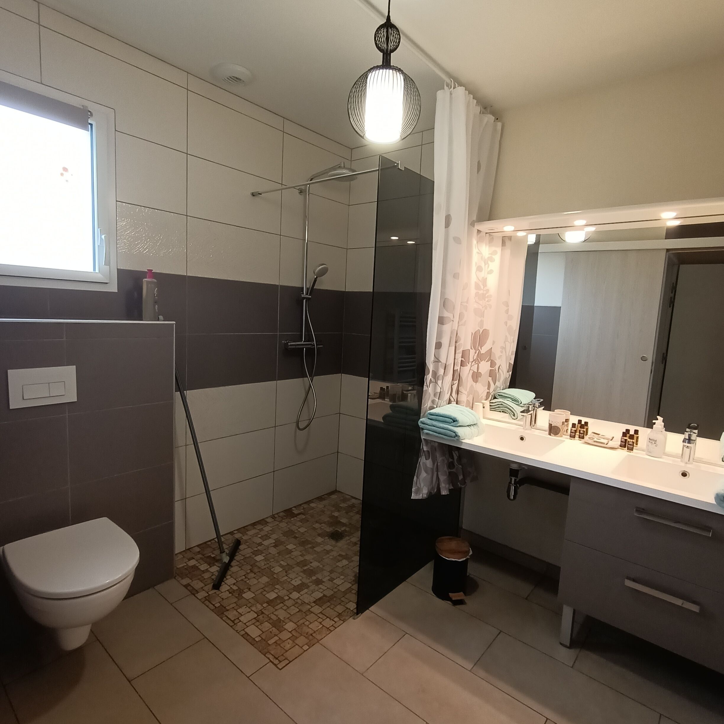 Une salle de bain avec douche, toilettes et lavabo.