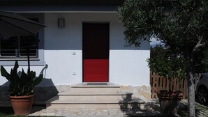 A modern house with a red door, stone steps, and potted plants. - Gens Mundi B&B (Rome)