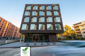Un moderno edificio de hotel con techo plano, múltiples ventanas y un letrero que dice "HARBR Hotel".