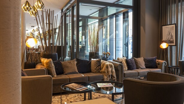 Una sala de estar moderna con sofá, mesa de centro e iluminación decorativa.
