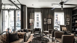 Una sala de estar moderna con un sofá, sillones, una mesa de centro y una estantería.