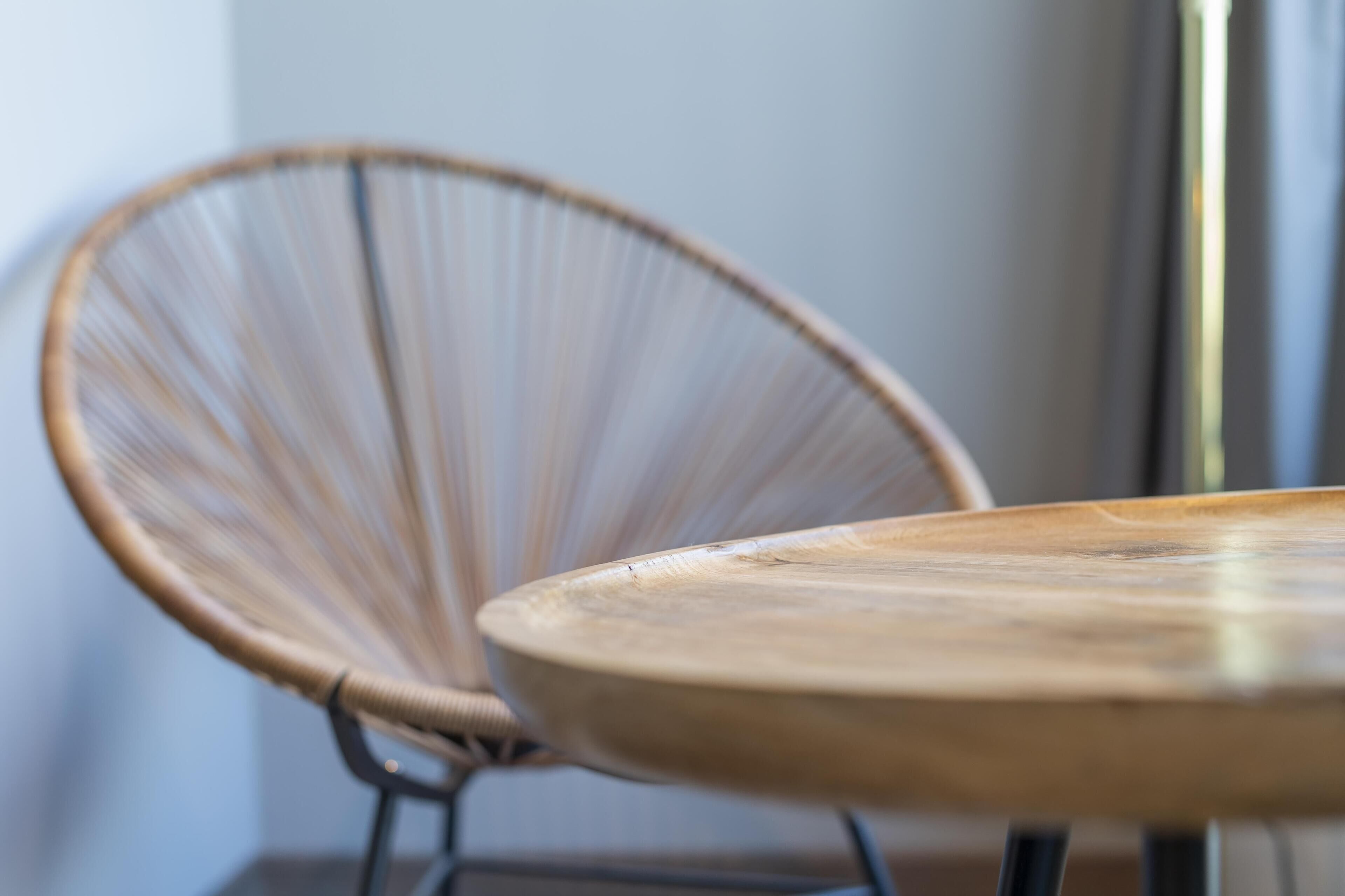 Een ronde houten tafel met een metalen onderstel.