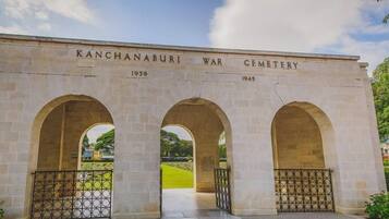 Un monumento de piedra con la inscripción "KANCHANABURI WAR CEMETERY" y las fechas "1939" y "1945".