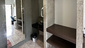 Um banheiro moderno com um espelho grande, área de chuveiro e um banco embutido.