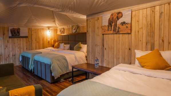 Une chambre avec deux lits, des murs en bois et un tableau représentant un éléphant.