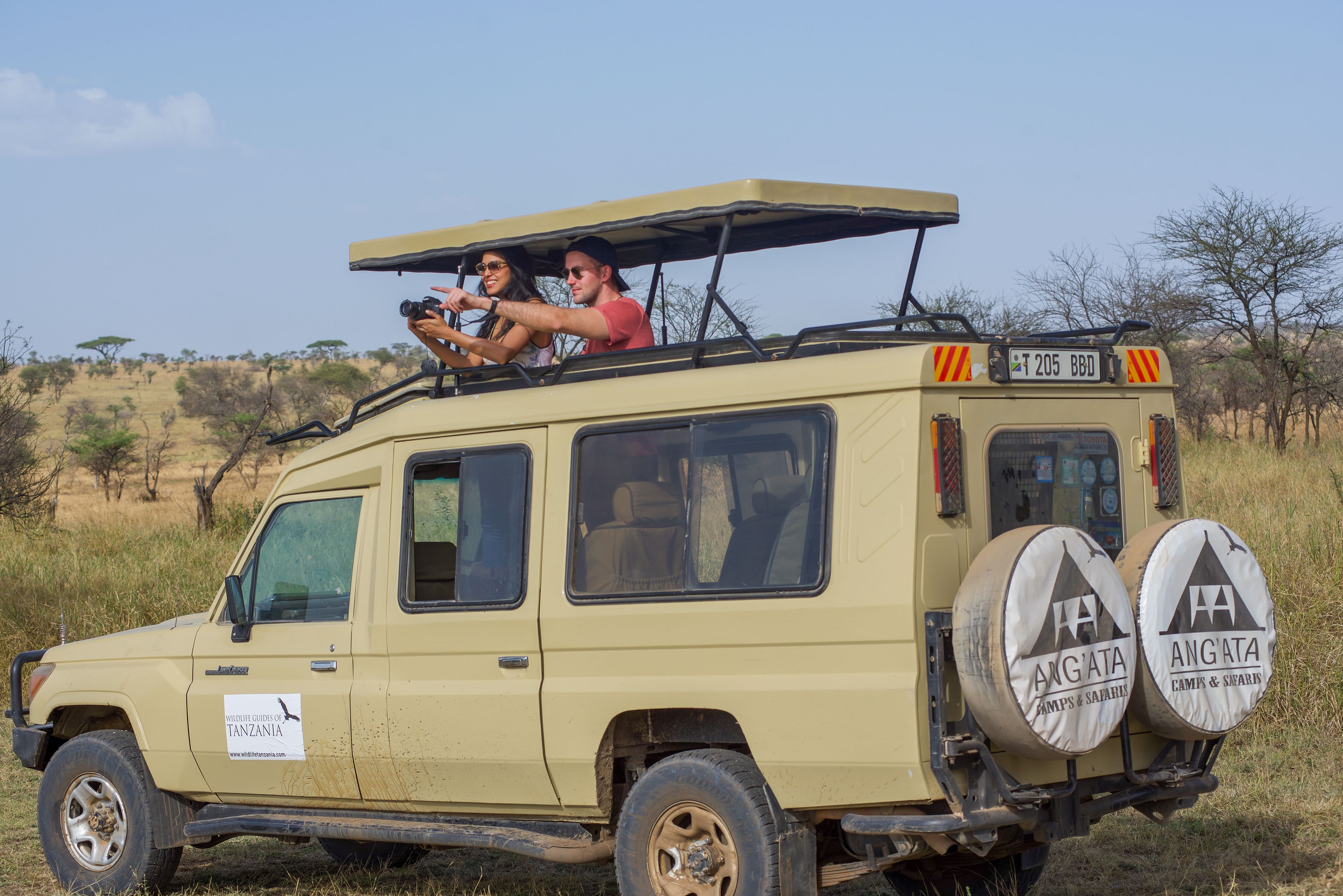 Un véhicule de safari doté d’un toit, de deux pneus de secours et d’un panneau indiquant qu’il s’agit d’un véhicule d’accompagnement pour les safaris en Tanzanie.