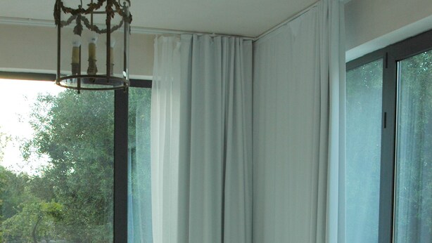A bedroom with a large bed, a chair, and a view of the outdoors through a window. - Ulivi Al Sole - Charming B&B (Francavilla Fontana)