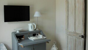 A room with a grey console table, a white lamp, a black TV, and a white door. - Ulivi Al Sole - Charming B&B (Francavilla Fontana)