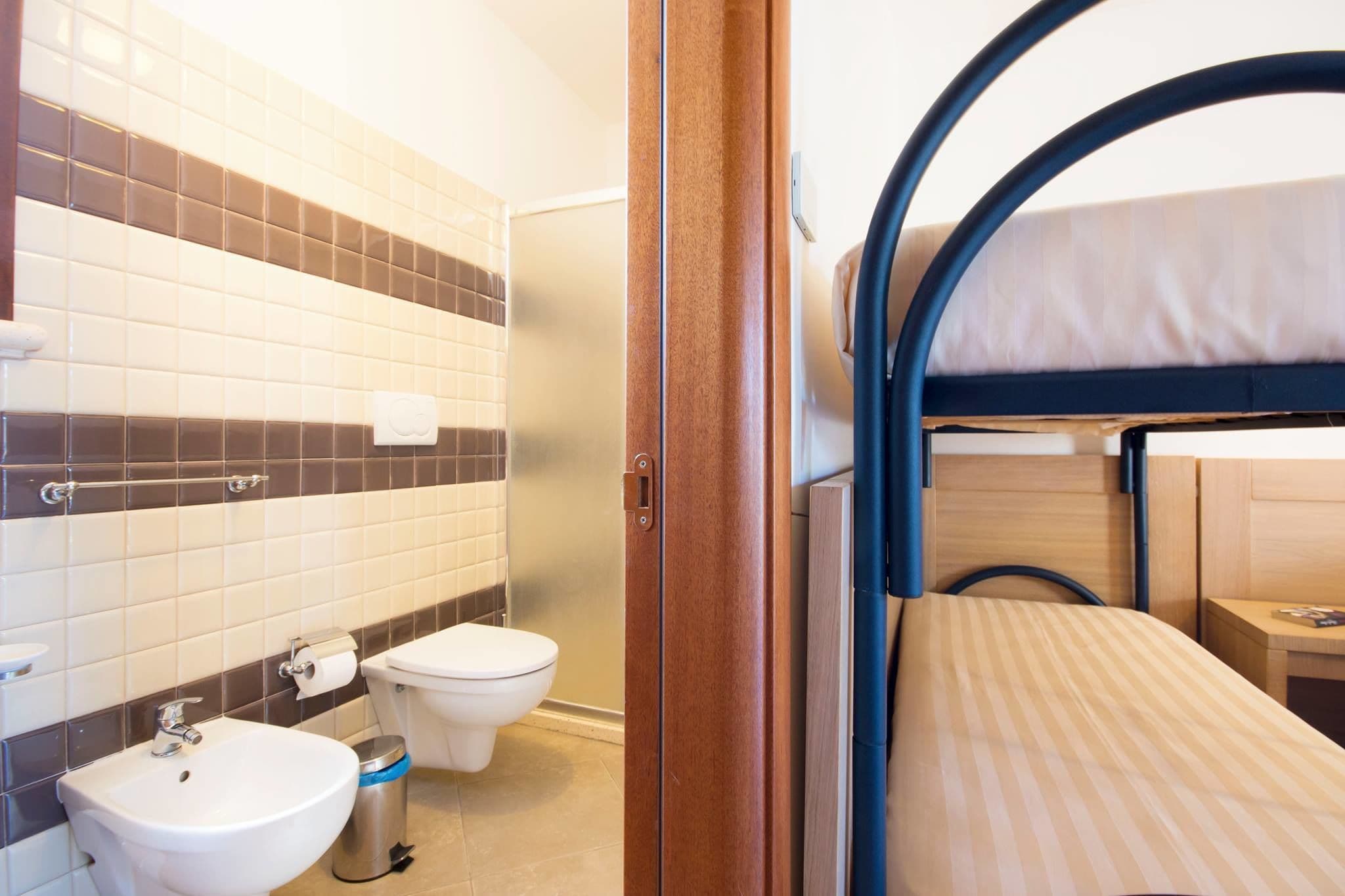 Un baño pequeño con lavamanos, inodoro y ducha.
