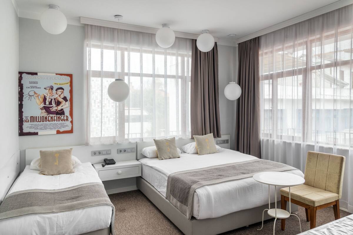 Ein Hotelzimmer mit zwei Betten, einem kleinen Tisch und einem Stuhl.
