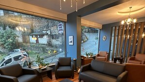 Ein modernes Wohnzimmer mit großem Fenster, einer Kristallleuchtre und Ledermöbeln.