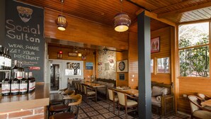 A cozy bar area with wooden furniture, a dartboard, and a chalkboard sign. - Bucoleon Hostel (Istanbul)