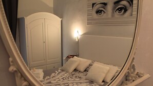 A bedroom with a bed, a wardrobe, and a wall-mounted light fixture. - Golfo Della Luna (La Spezia)