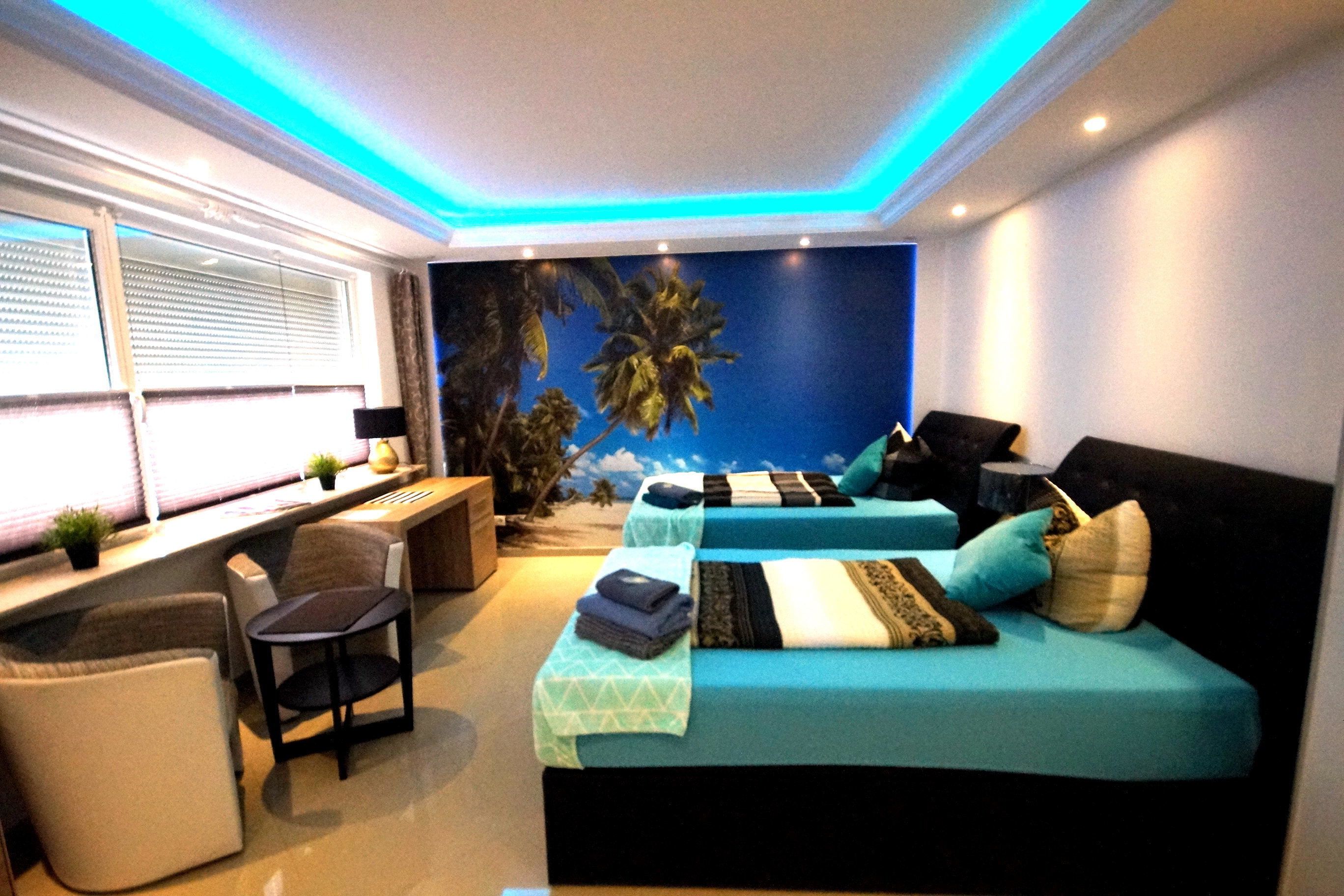 Una habitación con dos camas, un escritorio y una silla.
