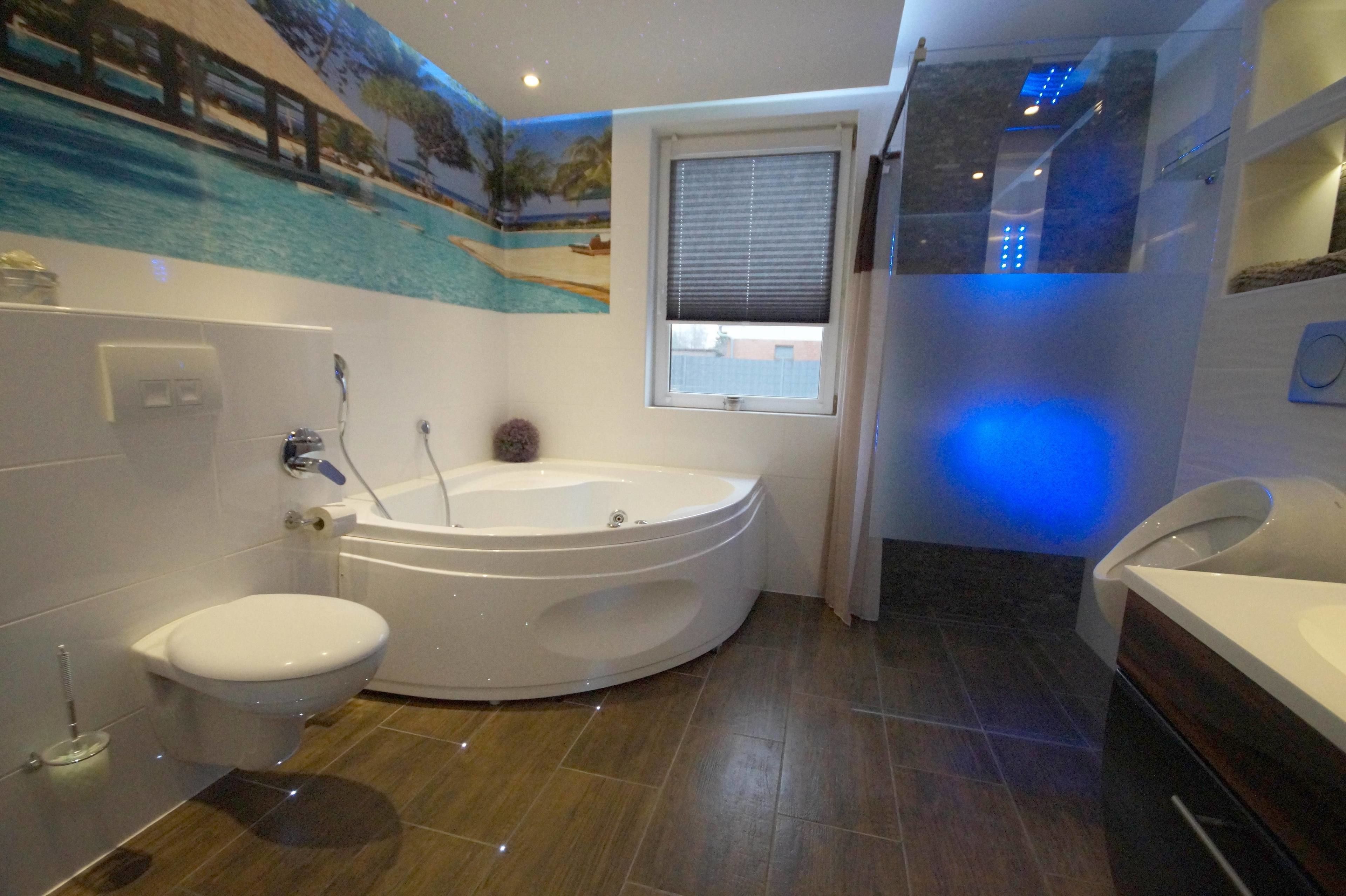 A modern bathroom with a bathtub, toilet, and sink.