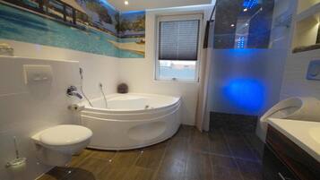 A modern bathroom with a bathtub, toilet, and sink.