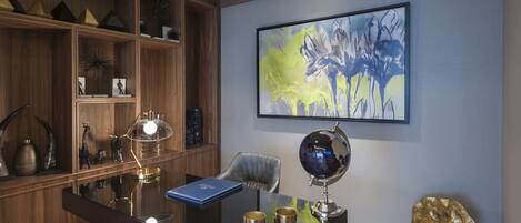 A modern office with a wooden desk, a globe, and a blue book.