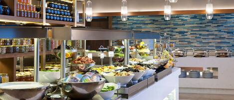 A buffet with various food items and condiments.