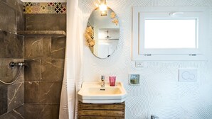 A bathroom with a shower, a sink with a mirror, and a window. - B&B la di Cesar (Aiello del Friuli)