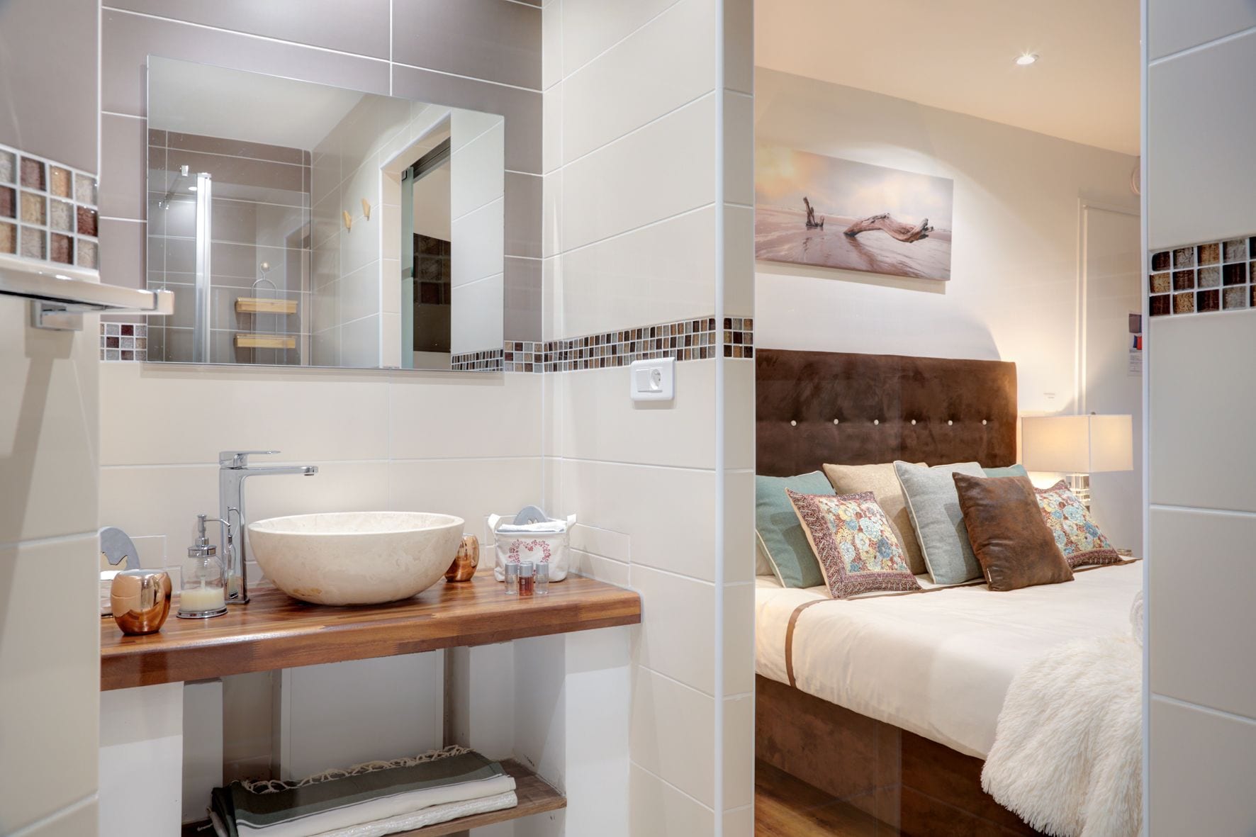 Un baño moderno con un espejo grande, azulejos blancos y un mueble de tocador de madera.
