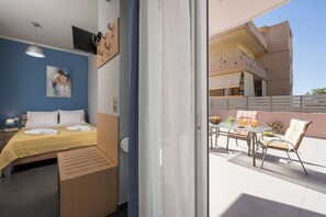 A hotel room with a bed, bedside table, and a view of the balcony. - Astrantia-Adults Only (Chania)