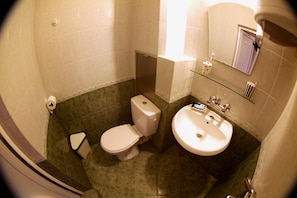 A small bathroom with a toilet, sink, and mirror.
