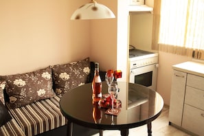 Un salon confortable avec un canapé, une table en verre, une bouteille et un verre à vin.
