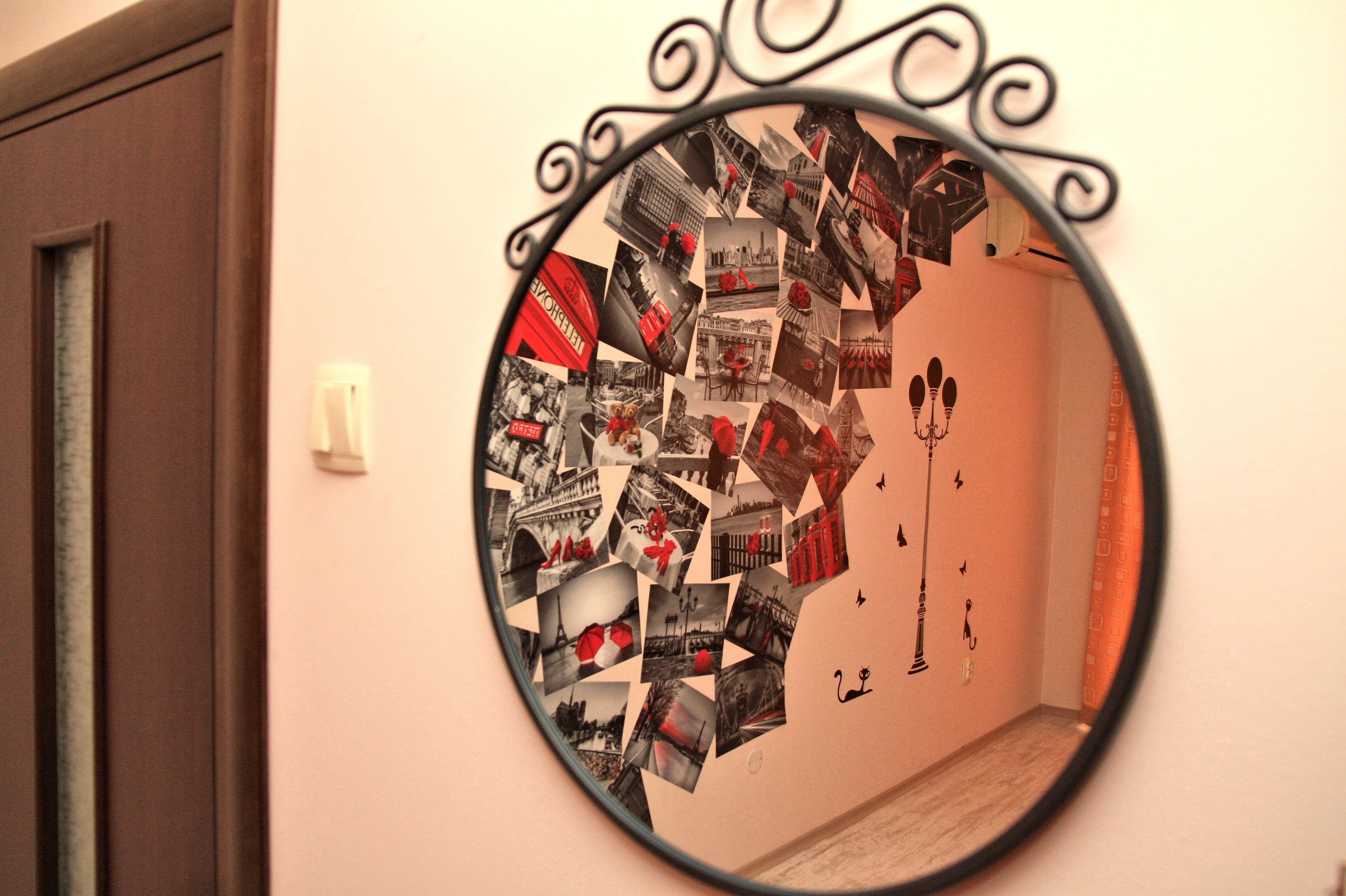 Un miroir rond orné d’un collage de photos sur sa surface, fixé au mur.