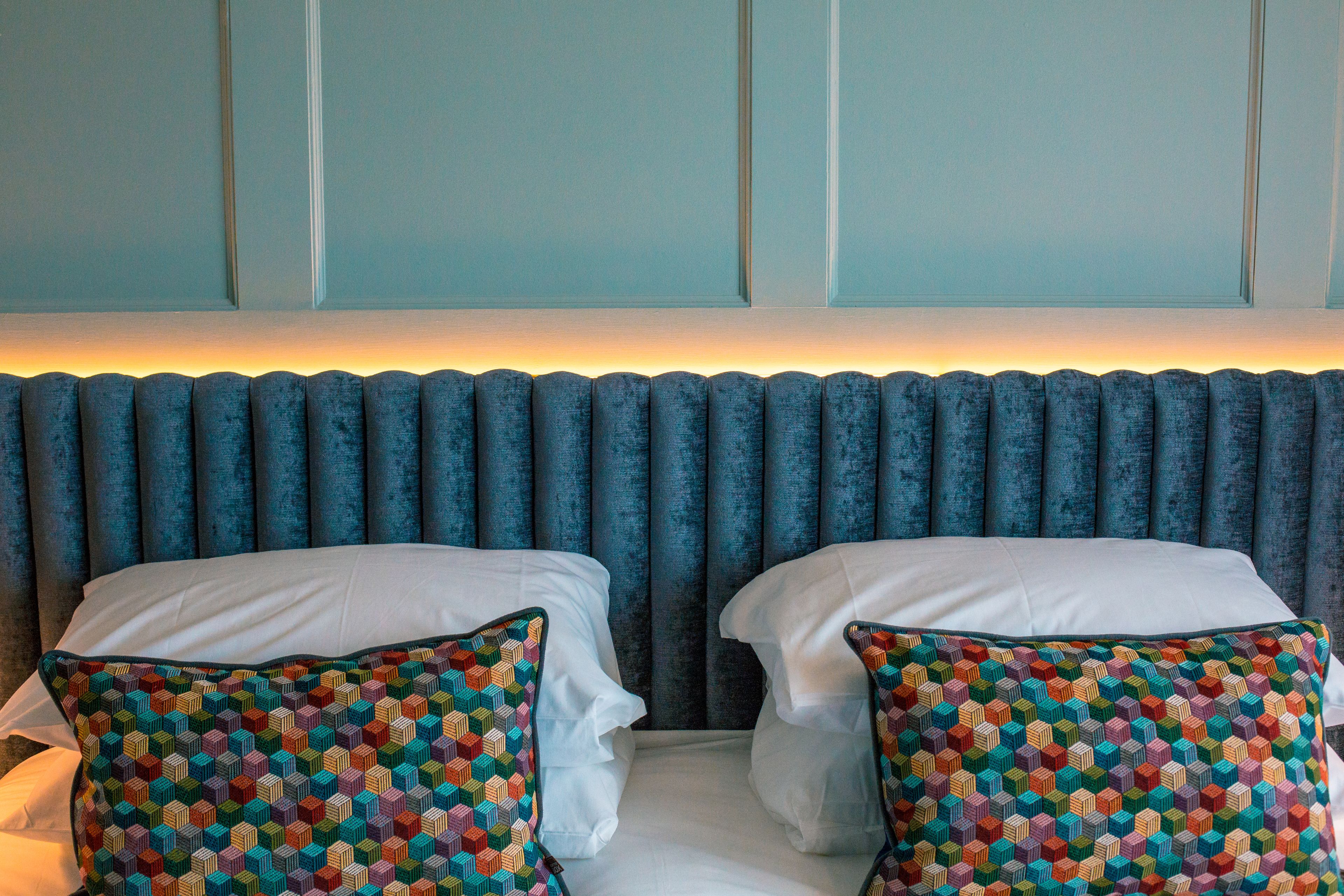 Een bed met twee kussens en een hoofdbord met verticale panelen.