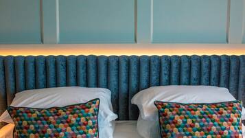 Een bed met twee kussens en een hoofdbord met verticale panelen.