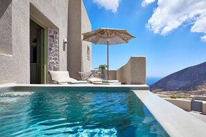 A modern infinity pool with a clear view of the ocean and a mountainous landscape. - Aeon Suites - Adults Only by Mr and Mrs White (Santorini)